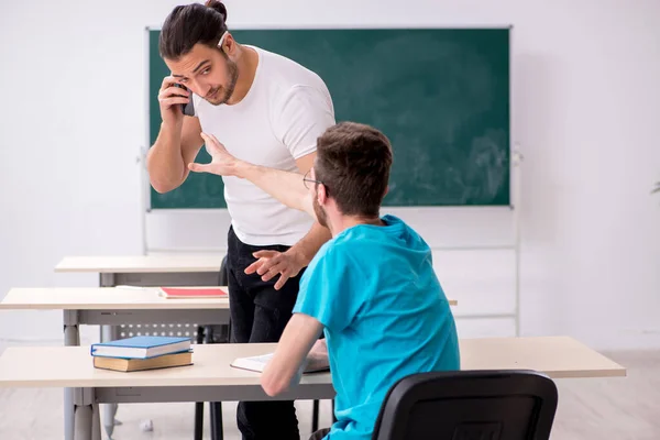 Two male pupils in bullying concept in the classroom — Stock Photo, Image