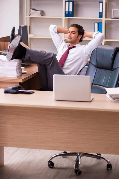 Jovem funcionário masculino extremamente cansado com excesso de trabalho — Fotografia de Stock