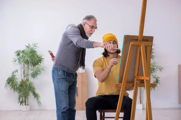 Joven tomando lecciones del viejo pintor —  Fotos de Stock