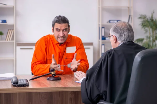 Oude mannelijke rechter ontmoeting met jonge gevangene in gerechtsgebouw — Stockfoto