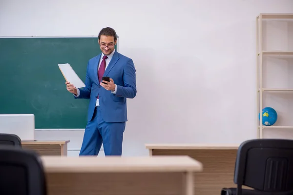 緑のボードの前でスーツの若い男性教師 — ストック写真
