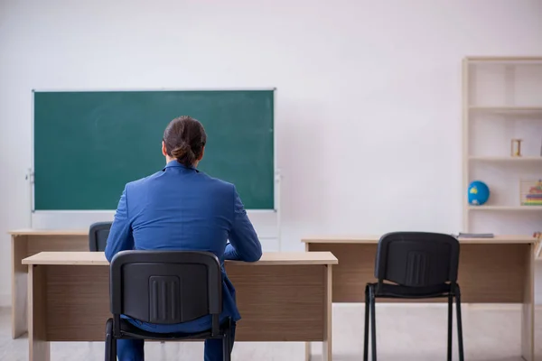 Joven profesor de traje delante del tablero verde —  Fotos de Stock