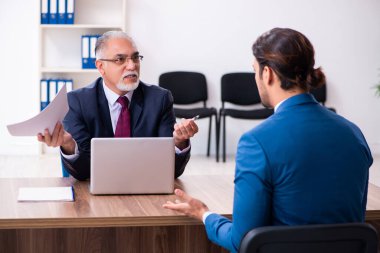 Genç bir erkek aday, yaşlı bir askerle görüşüyor.