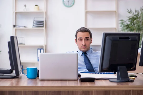 Jonge mannelijke werknemer ongelukkig met overmatig werk — Stockfoto