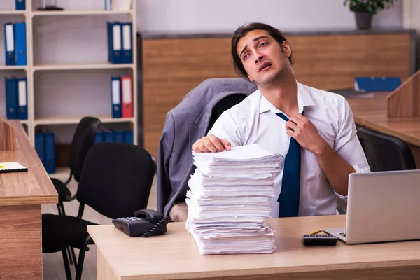 Joven empleado masculino descontento con el trabajo excesivo en la oficina — Foto de Stock