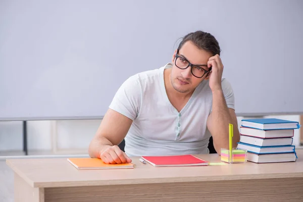 Junge männliche Lehramtsstudentin sitzt im Klassenzimmer — Stockfoto