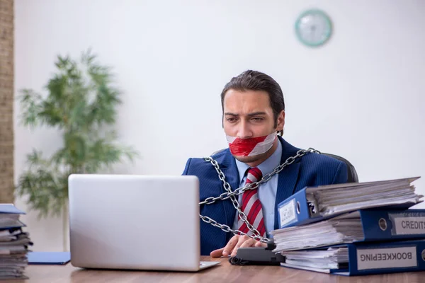 Angeketteter männlicher Mitarbeiter unzufrieden mit exzessiver Arbeit im Büro — Stockfoto