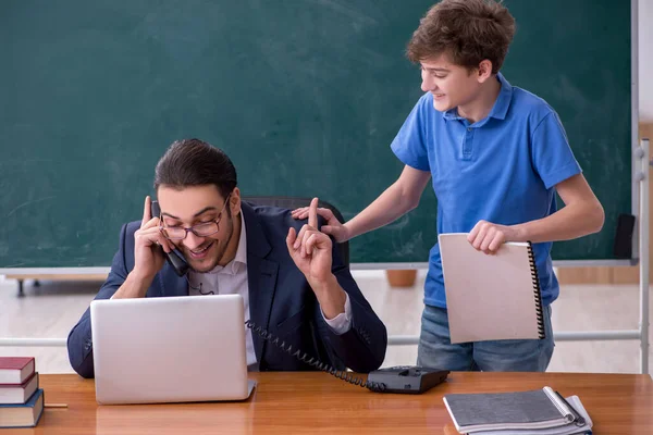 Jeune enseignant et écolier dans la salle de classe — Photo