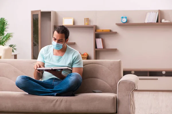 Ung mannlig student som studerer hjemme under pandemi – stockfoto