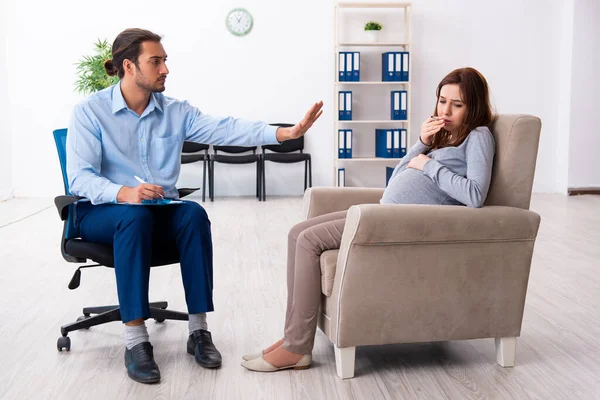 Έγκυος γυναίκα που επισκέπτεται νεαρό άνδρα ψυχολόγο — Φωτογραφία Αρχείου