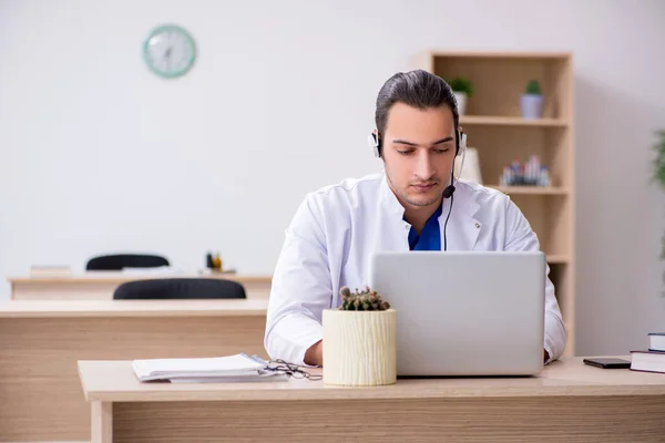 Jonge mannelijke arts in telegeneeskunde concept — Stockfoto