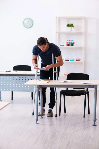 Jonge mannelijke student na ongeval voorbereiding voor examens — Stockfoto