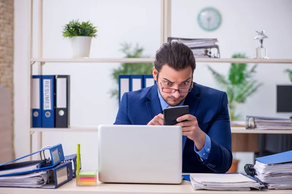 Empleado joven empresario infeliz con el trabajo excesivo — Foto de Stock