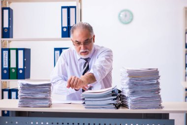 Ofisteki aşırı işten memnun olmayan yaşlı bir erkek işçi.