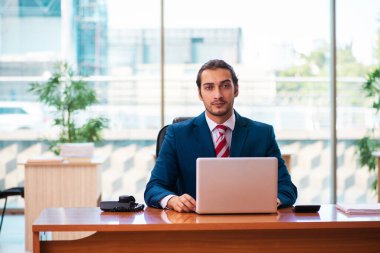 Ofiste çalışan yakışıklı bir genç.