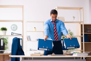 Genç erkek çalışan iş yerinde spor egzersizleri yapıyor.