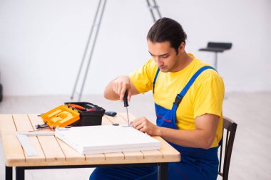 Genç erkek marangoz içeride çalışıyor.