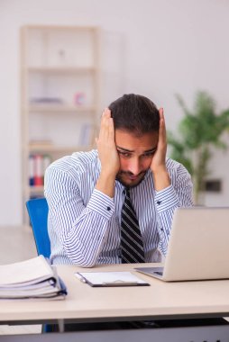 Ofiste çalışan genç bir erkek.