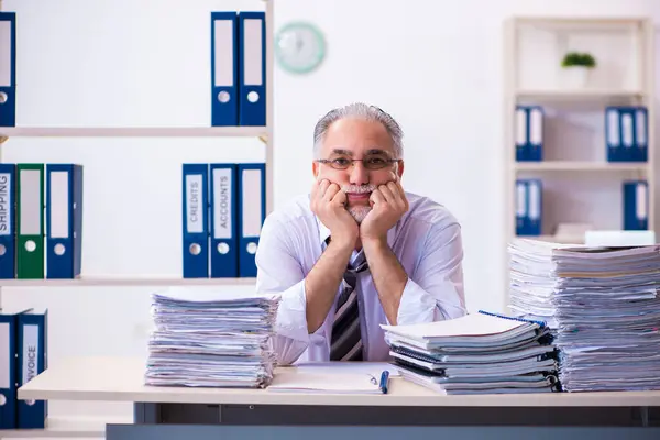 Oude mannelijke werknemer ongelukkig met overmatig werk in het kantoor — Stockfoto