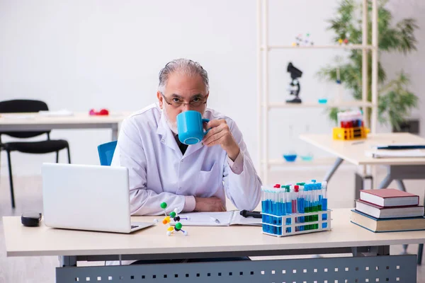 Stary chemik pracujący w laboratorium. — Zdjęcie stockowe