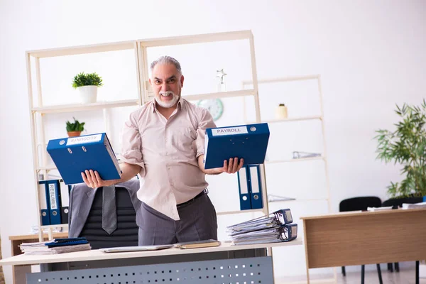 Velho funcionário do sexo masculino fazendo exercícios físicos no local de trabalho — Fotografia de Stock