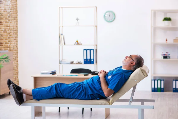 Old male doctor extremely tired after night shift — Stock Photo, Image