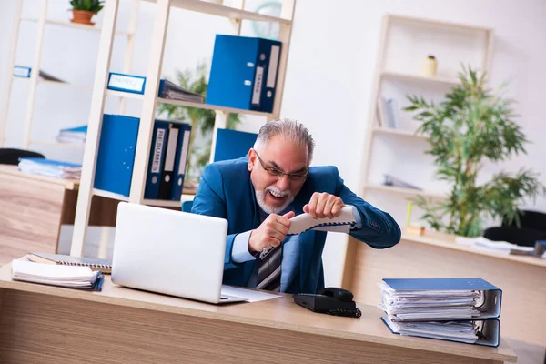 Alte Buchhalterin unzufrieden mit exzessiver Arbeit am Arbeitsplatz — Stockfoto