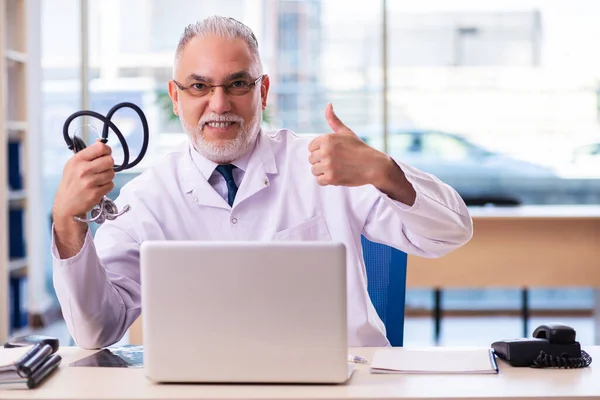 Klinikte çalışan yaşlı erkek doktor. — Stok fotoğraf