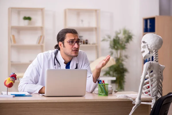 Young male doctor and skeleton patient in the clinic — Stock Photo, Image