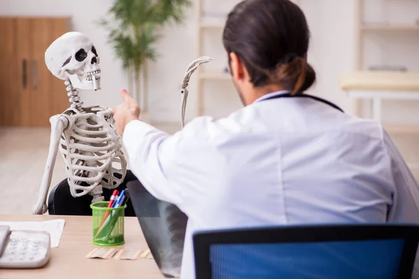 Hombre joven radiólogo médico y paciente esqueleto en la clínica —  Fotos de Stock