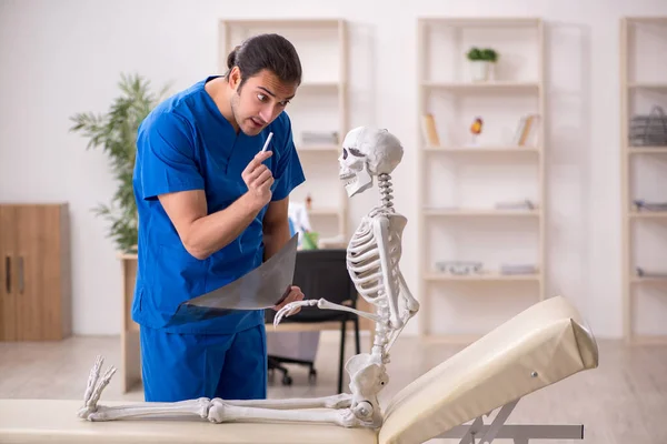 Jovem médico e paciente esqueleto do sexo masculino no conceito de antitabagismo — Fotografia de Stock