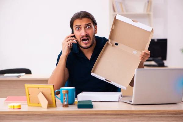 Junge männliche Angestellte bestellt Pizza am Arbeitsplatz — Stockfoto