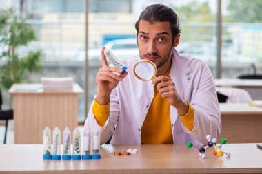 Genç erkek kimyager uyuşturucu sentezi konseptinde