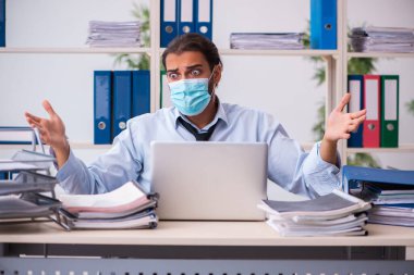 Salgın sırasında ofiste çalışan genç bir erkek.