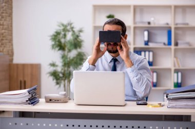 İş yerinde sanal gözlük takan genç bir erkek çalışan.