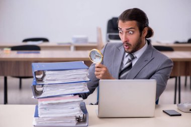 Ofisteki aşırı işten memnun olmayan genç bir erkek işçi.