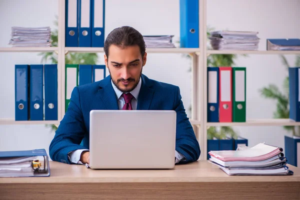 Jeune employé masculin et trop de travail au bureau — Photo