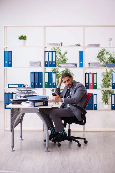 Young male employee unhappy with excessive work in the office — Stock Photo, Image