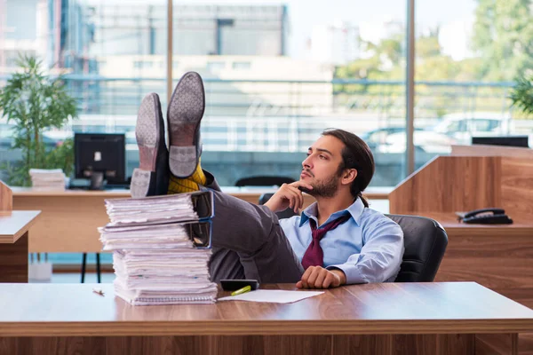 Young male employee unhappy with excessive work in the office — Stock Photo, Image