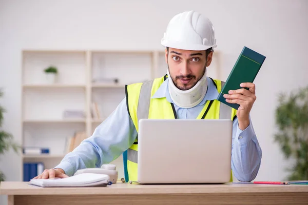 Young neck injured male architect in safety concept — Stock Photo, Image