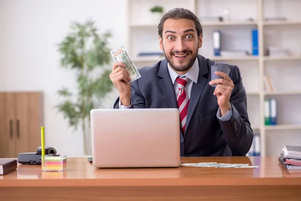 Young male employee playing cards at workplace