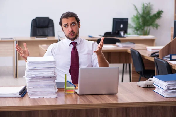 Junge männliche Angestellte unzufrieden mit exzessiver Arbeit im Büro — Stockfoto