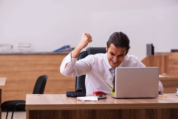 Junge männliche Angestellte heften Papier im Büro — Stockfoto