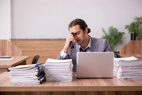 Jovem funcionário masculino infeliz com excesso de trabalho no escritório — Fotografia de Stock