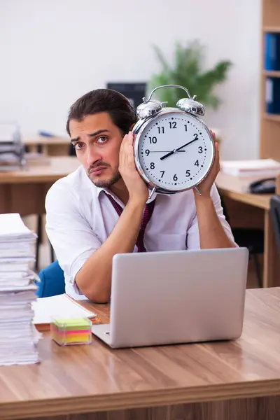 Jeune employé masculin dans le concept de gestion du temps au bureau — Photo