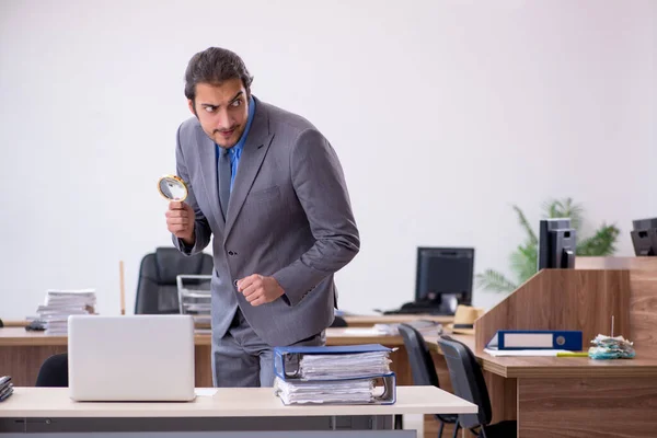 Young male employee in industrial espionage concept