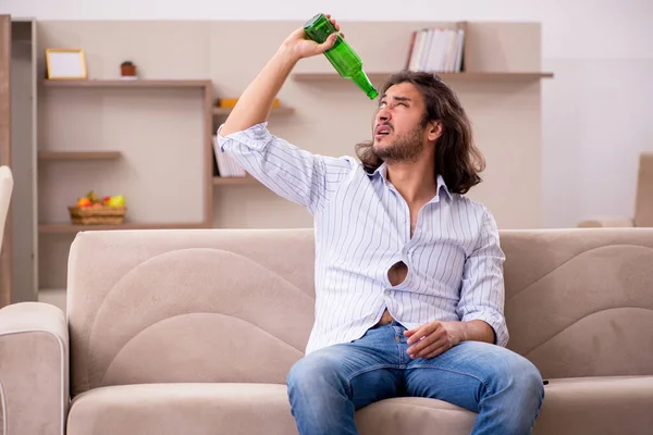 Junger Mann trinkt zu Hause Alkohol — Stockfoto