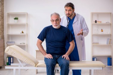 Yaşlı erkek hasta genç erkek doktoru ziyaret ediyor.