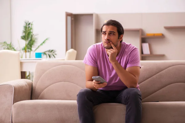 Joven viendo televisión en casa durante pandemia — Foto de Stock