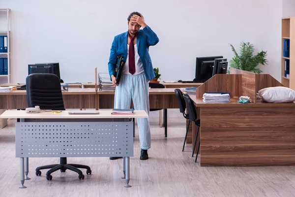 Junge männliche Mitarbeiter kommen direkt aus dem Bett zur Arbeit — Stockfoto